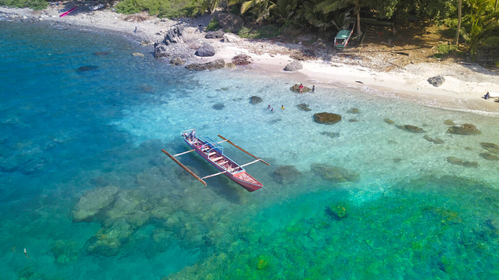 Traditional boat with Beautiful nature of blue sea sand and Turquoise color water waves at Atauro Island, Timor Leste