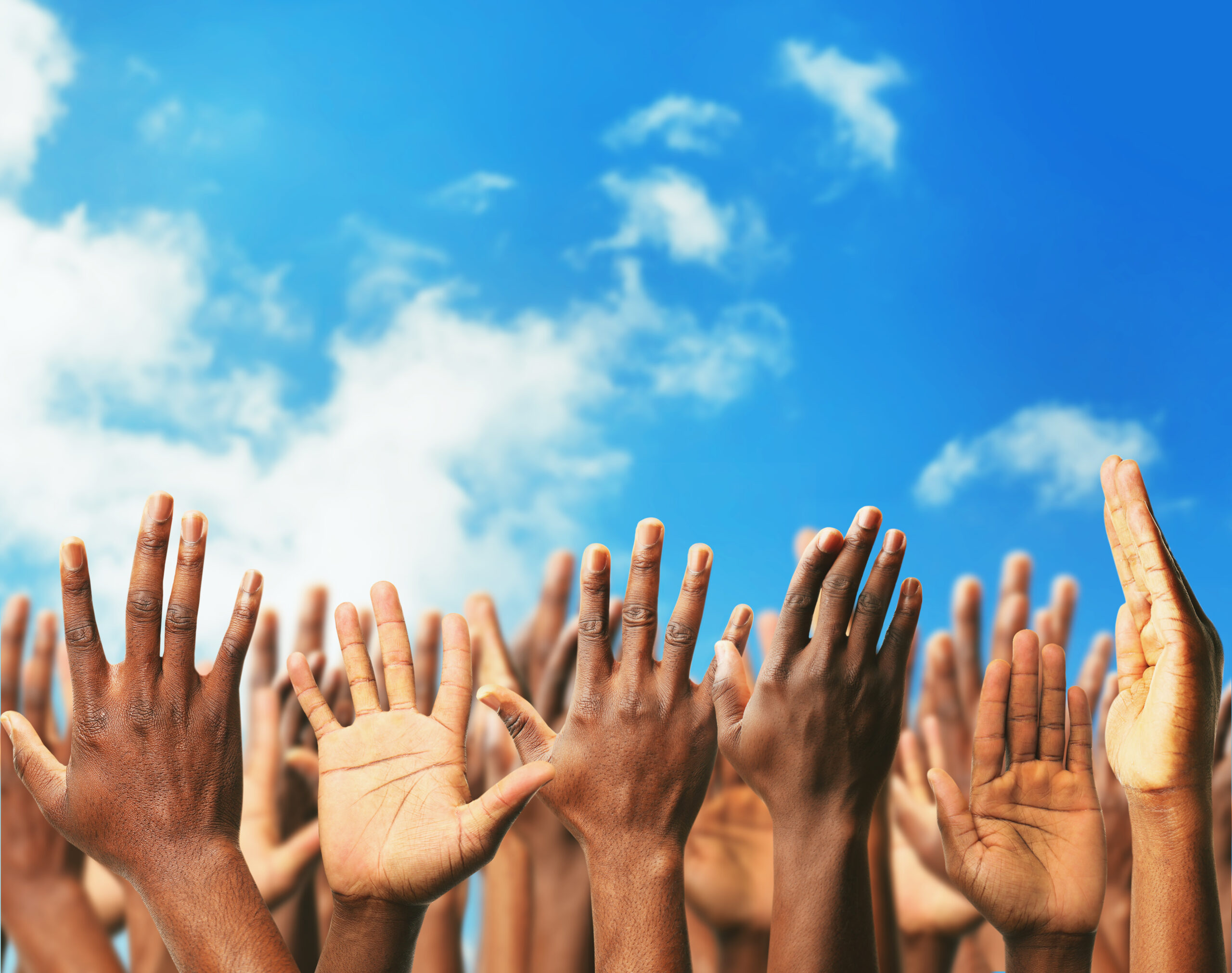 Hands raising towards the blue sky